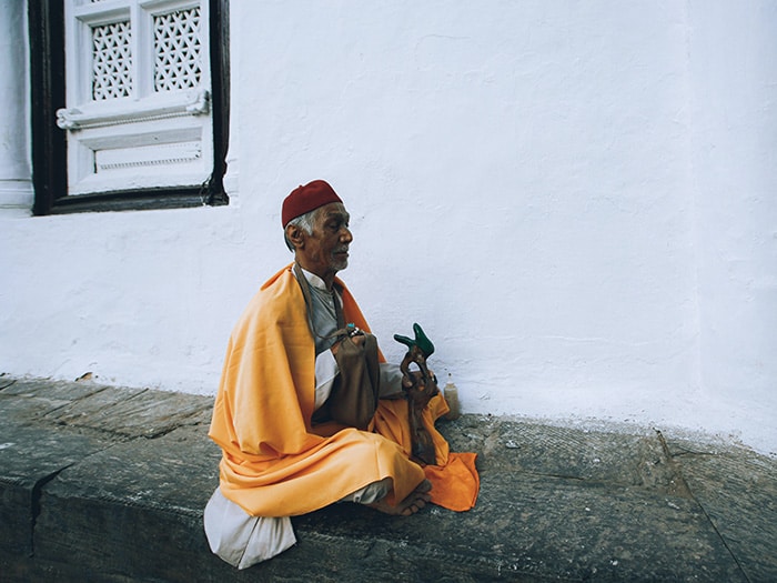 Indian men meditating with a orange shawl